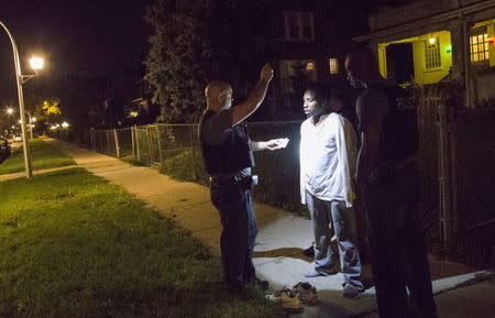 Cook County Sheriff police officers handcuff and question a man who walked up to them while officers where conducting an unrelated street stop in the Austin neighborhood in Chicago, Illinois, United States, September 9, 2015. REUTERS/Jim Young