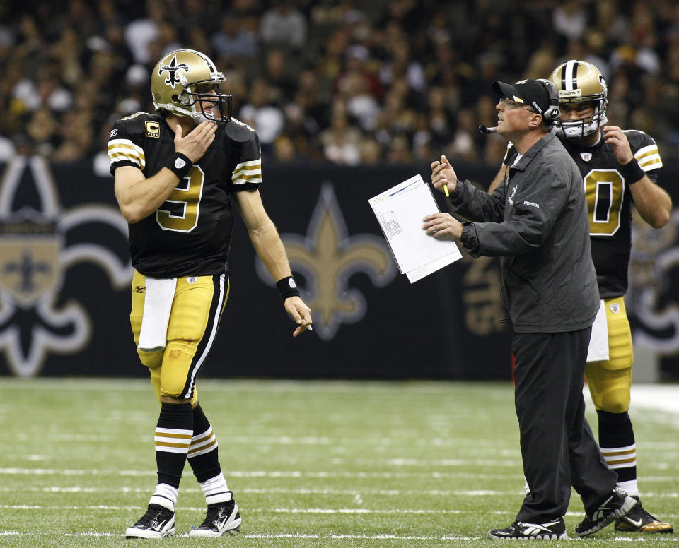 FILE - New Orleans Saints quarterback Drew Brees (9) talks to then-quarterbacks coach Pete Carmichael, Jr. during the second quarter of an NFL football game against the Tampa Bay Buccaneers in New Orleans, Sunday, Nov. 6, 2011. This weekend in Atlanta, the Saints debut an offense now run exclusively by long-time Sean Payton understudy Pete Carmichael Jr. (AP Photo/Jonathan Bachman, File)
