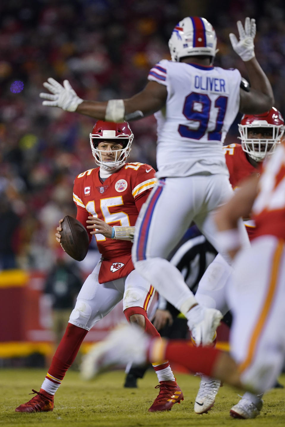 Kansas City Chiefs quarterback Patrick Mahomes (15) looks to pass around Buffalo Bills defensive tackle Ed Oliver (91) during the second half of an NFL divisional round playoff football game, Sunday, Jan. 23, 2022, in Kansas City, Mo. (AP Photo/Ed Zurga)