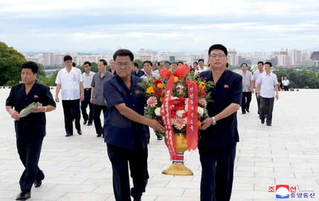 People hold floral tributes in North Korea