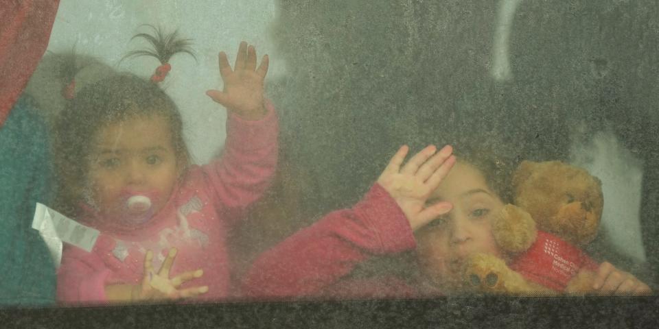 Children looking through bus window