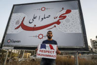 An Arab Israeli Muslim demonstrator, clad in mask due to the COVID-19 coronavirus pandemic, holds up a sign during a rally protesting against the comments of French President Emmanuel Macron over Prophet Mohammed cartoons, in the Arab town of Umm-Al Fahem in Northen Israel on October 25, 2020. (Photo by Ahmad GHARABLI / AFP) (Photo by AHMAD GHARABLI/AFP via Getty Images)