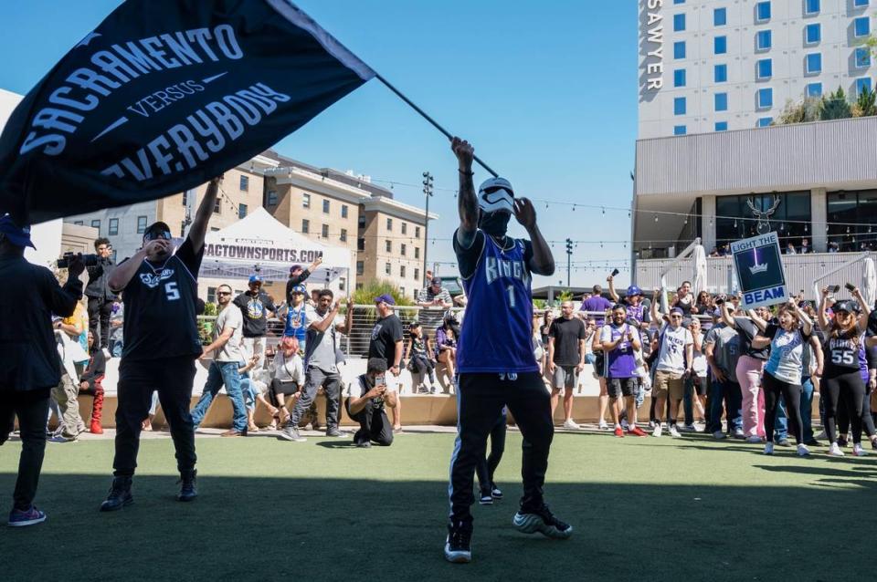 Mike Steeze waves a “Sacramento versus everybody” flag he created with his daughter Adelle, 6, behind him, before Game 7 of the first-round NBA playoff series at Golden 1 Center on Sunday, April 30, 2023.