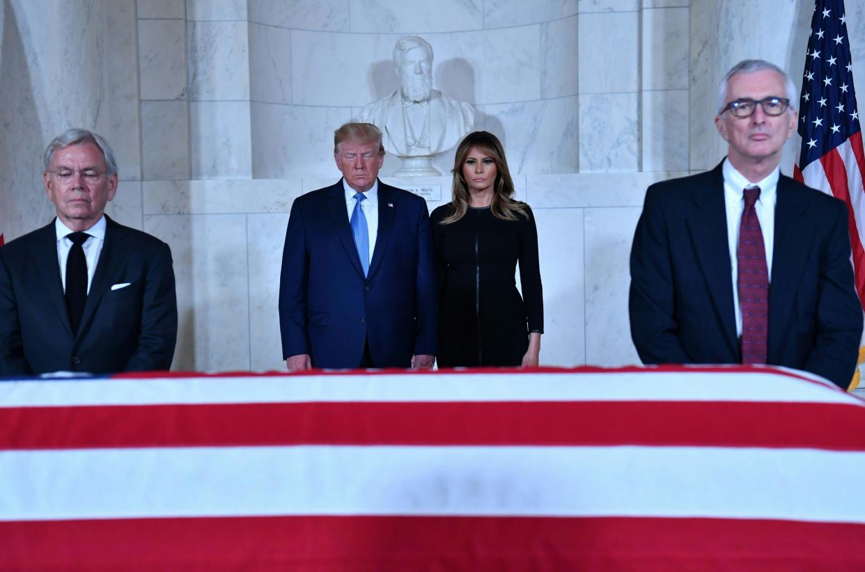 President Donald Trump and First Lady Melania Trump pay their respects before the flag-draped casket of late Supreme Court Justice John Paul Stevens in the Great Hall of the Supreme Court in Washington on Monday, July 22, 2019.