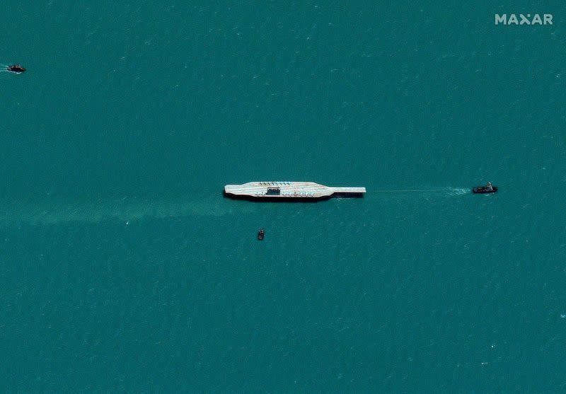 Iran's refurbished mockup aircraft carrier is seen towed by a tugboat near Bandar Abbas