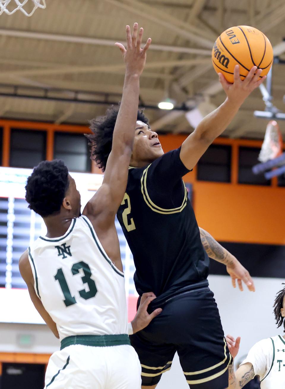 Midwest City's Roy Henderson shoots as Norman North's Hezekiah Green defends during the Putnam City Invitational championship game Saturday at Putnam City.