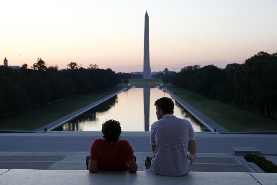 FILE - In this June 7, 2020, file photo, visitors watch sunrise from the Lincoln Memorial steps in Washington, the morning after massive protests over the death of George Floyd, who died after being restrained by Minneapolis police officers. (AP Photo/Patrick Semansky, File)