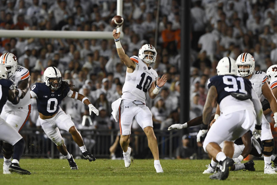 Auburn quarterback Bo Nix (10) passes while being pressured by Penn State safety Jonathan Sutherland (0) during an NCAA college football game in State College, Pa., on Saturday, Sept. 18, 2021. (AP Photo/Barry Reeger)