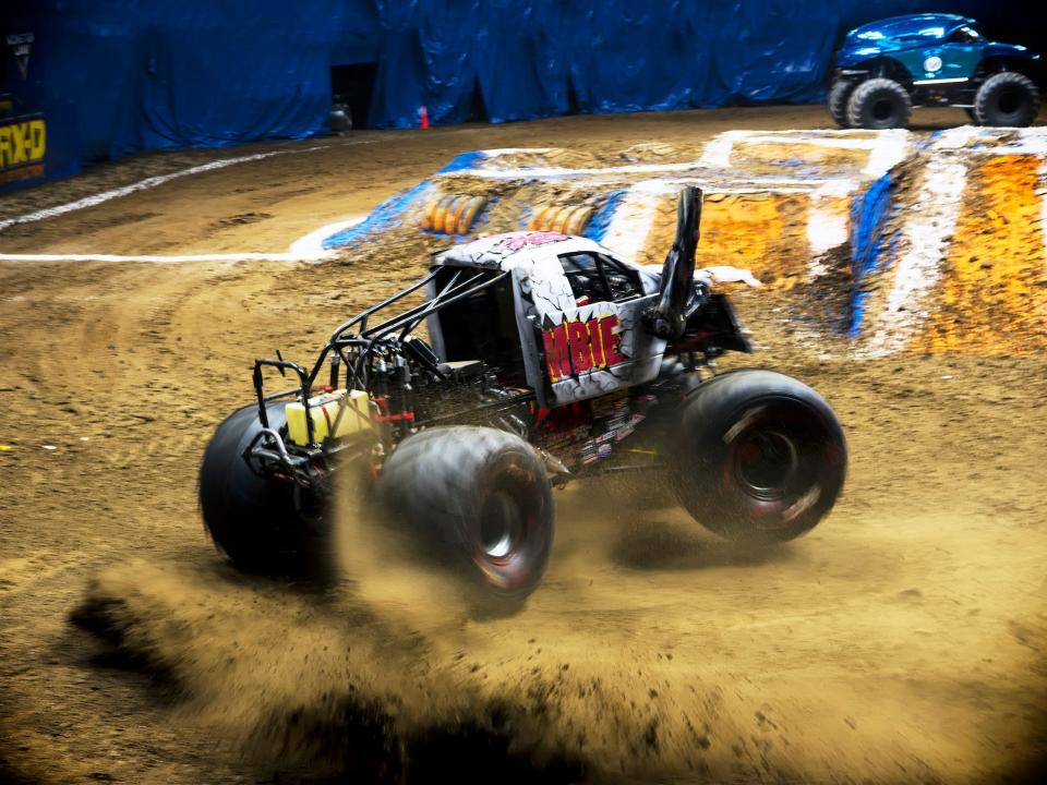A photo of a monster truck spinning in dirt