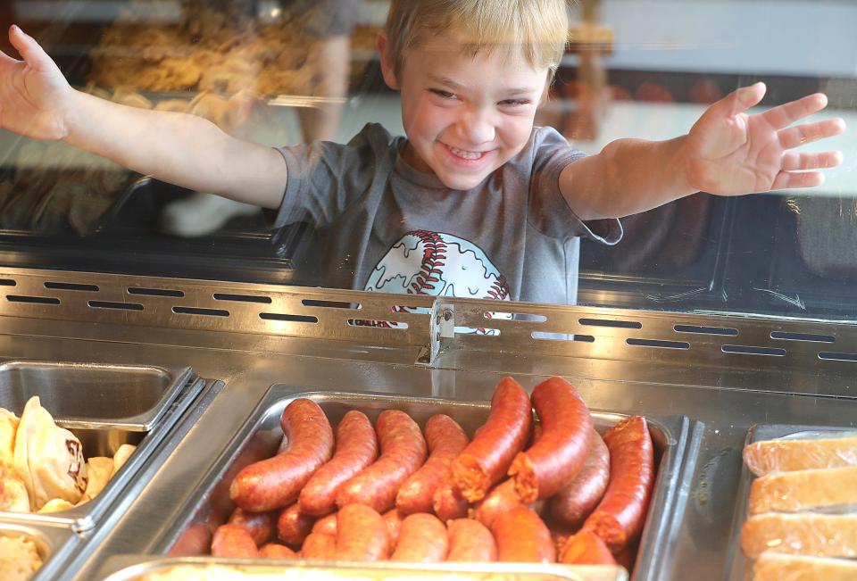 Baker Edwards 4, of Norton revels at the sausage behind the glass at Al's Corner Restaurant while his father Jordan Edwards gets lunch for Baker and his three brothers on Wednesday, August 16, 2023 in Barberton, Ohio. The restaurant is part of Al's Corner Market which has been a fixture in Barberton for 75 years. [Phil Masturzo/ Beacon Journal]