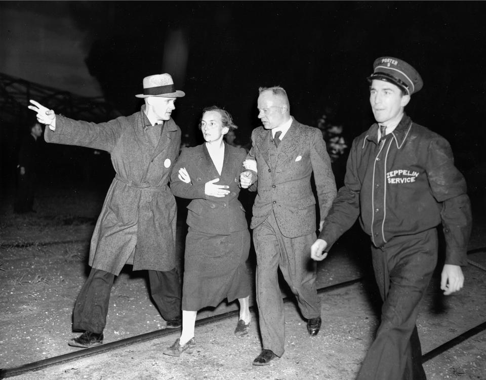 <p>An unidentified woman survivor is being led from the scene of the Hindenburg disaster at the U.S. Naval Station in Lakehurst, N.J., May 6, 1937. (AP Photo/Murray Becker) </p>