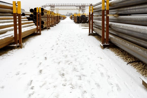 Stacks of pipe covered in snow.