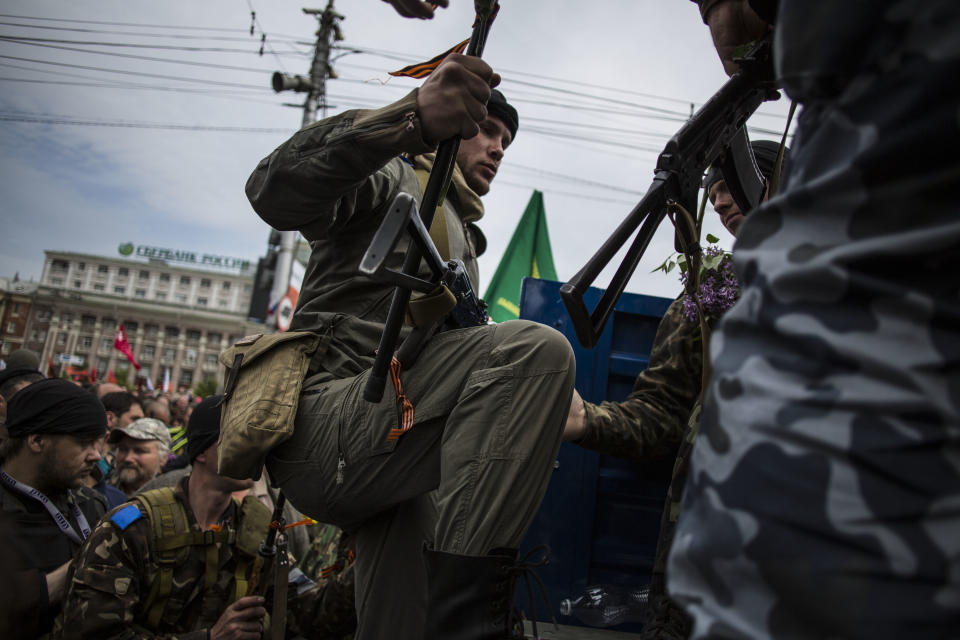 A pro-Russian gun man jumps on the back of a truck after the commemoration of Victory Day in Donetsk , Ukraine, Friday, May 9, 2014. Victory Day honors the armed forces and the millions who died in World War II. This year it comes as Russia is locked in the worst crisis with the West, over Ukraine, since the end of the Cold War. (AP Photo/Manu Brabo)