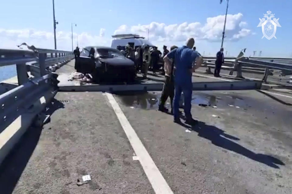 In this handout photo taken from video released by Investigative Committee of Russia on Monday, July 17, 2023, investigators work at an automobile link of the Crimean Bridge connecting Russian mainland and Crimean peninsula over the Kerch Strait not far from Kerch, Crimea. Traffic on the key bridge connecting Crimea to Russia's mainland was halted on Monday, July 17, after reports of explosions that Crimean officials said were from a Ukrainian attack. (Investigative Committee of Russia via AP)