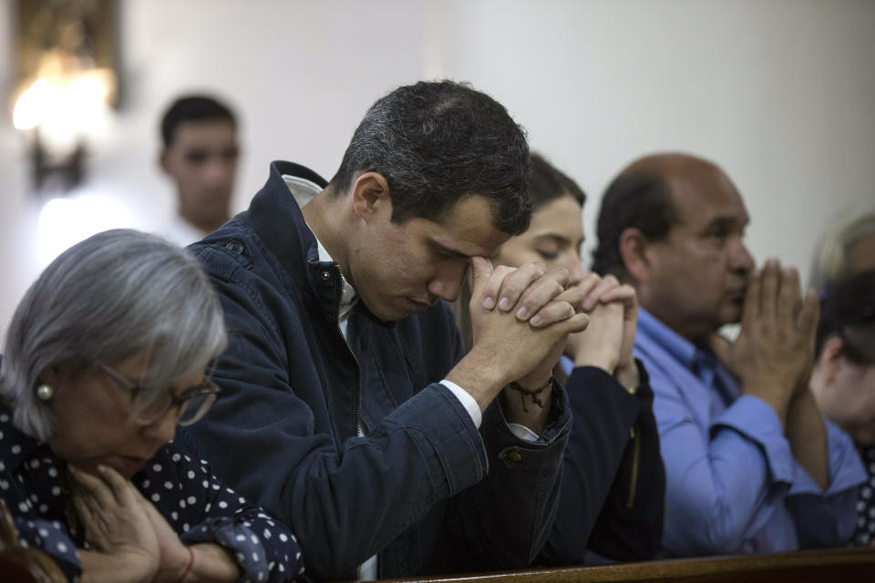 Opposition National Assembly President Juan Guaido, who declared himself interim president of Venezuela, prays next to his wife Fabiana Rosales, second from right, during Mass at a church in Caracas, Venezuela, Sunday, Jan. 27, 2019. Guaido says he is acting in accordance with two articles of the constitution that give the National Assembly president the right to hold power temporarily and call new elections. (AP Photo/Rodrigo Abd)