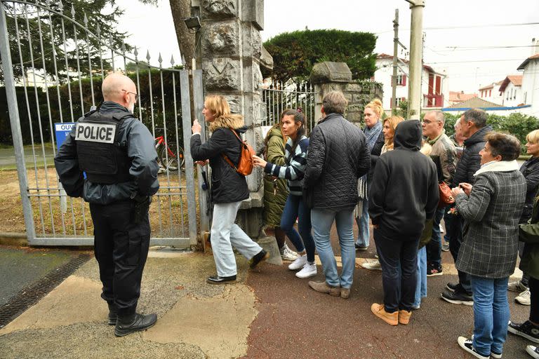 Un grupo de personas en la entrada de la escuela secundaria Saint-Thomas d'Aquin, donde sucedió el ataque