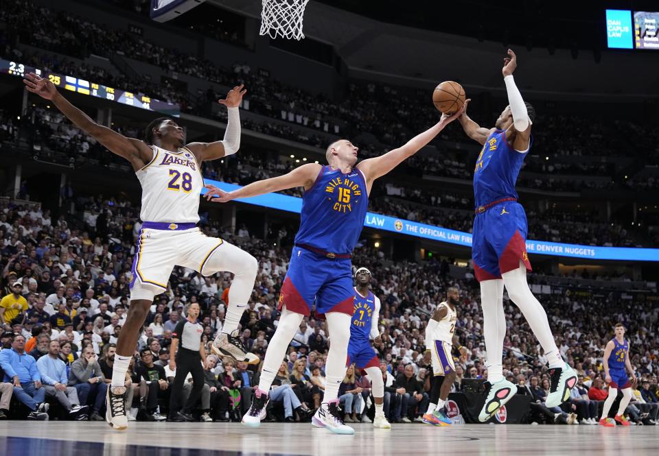 Denver Nuggets center Nikola Jokic (15) and Peyton Watson. right, reach for a rebound against Los Angeles Lakers forward Rui Hachimura (28) during the first half in Game 1 of an NBA first-round playoff series Saturday, April 20, 2024, in Denver. (AP Photo/Jack Dempsey)