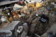 <p>Soldiers with specially trained dogs search for survivors amid the ruins of buildings knocked down Thursday night by a 8.1-magnitude quake, in Juchitan de Zaragoza, Mexico, on Sept. 9, 2017. (Photo: Pedro Pardo/AFP/Getty Images) </p>