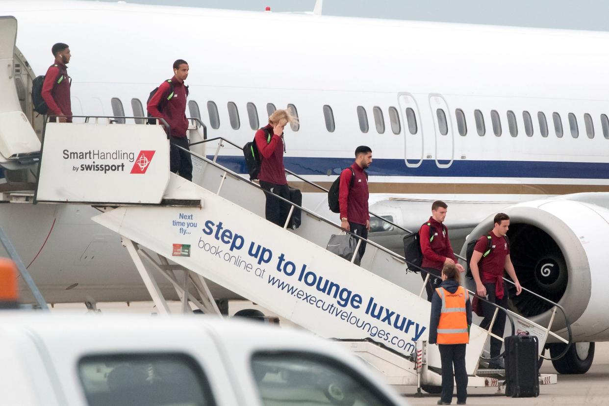 Liverpool players including Loris Karius, pictured with his hand over his face, get off their plane home at Liverpool's John Lennon airport: PA