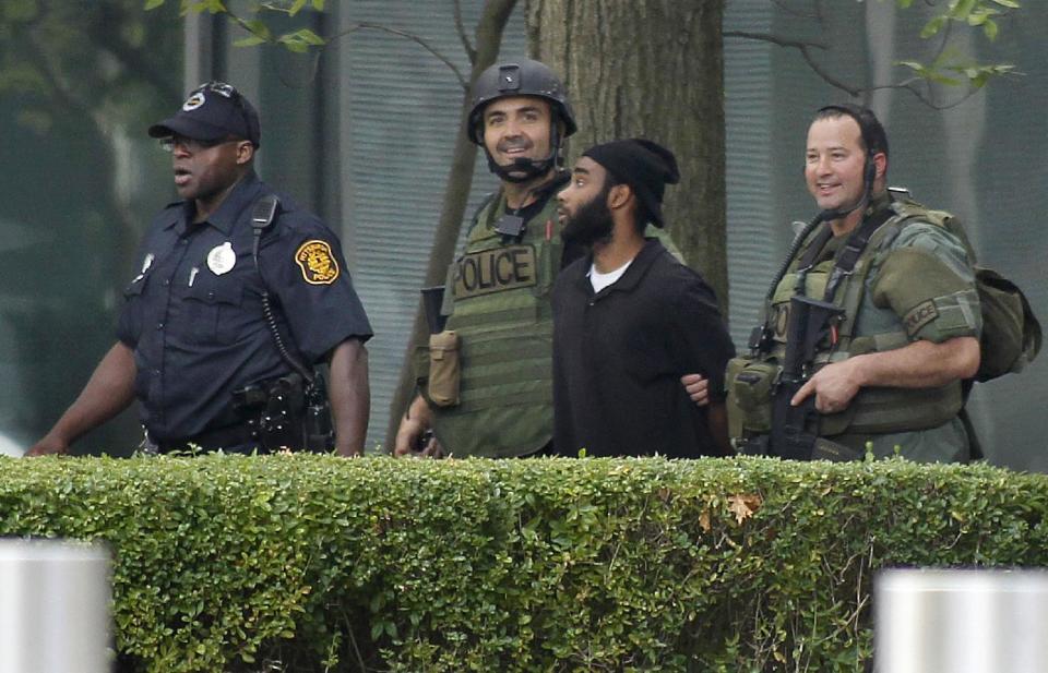 Pittsburgh police and SWAT members escort a suspect, center right, from a hostage-taking on the 16th floor at Three Gateway Center to a police van on Friday, Sept. 21, 2012, in Pittsburgh. Klein Michael Thaxton, 22, surrendered just before 2 p.m., and the man he took hostage was unhurt, Police Chief Nathan Harper said. (AP Photo/Keith Srakocic)