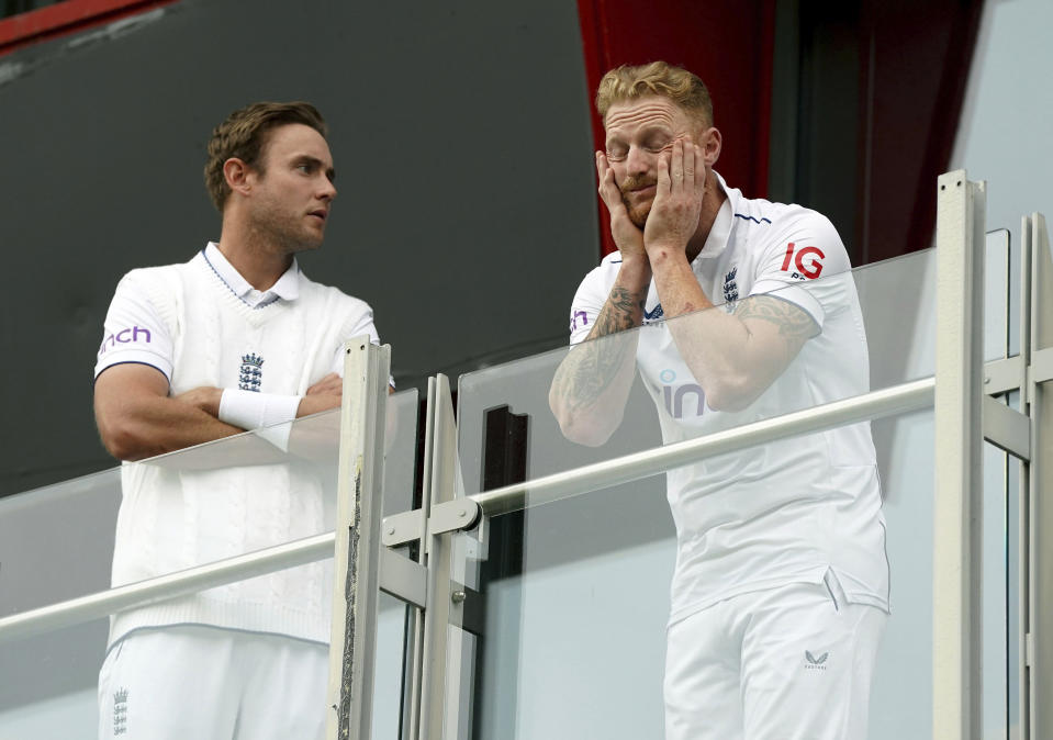 England's Stuart Broad, left and Ben Stokes look out from the players balcony after play was abandoned on the fourth day of the fourth Ashes Test match between England and Australia at Old Trafford, Manchester, England, Saturday, July 22, 2023. (Nick Potts/PA via AP)