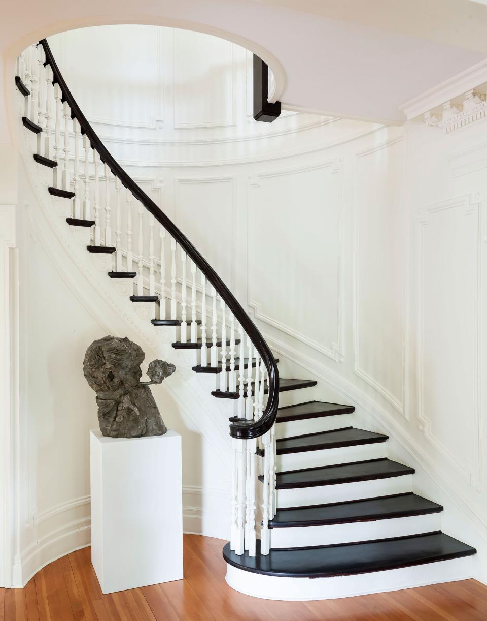 A curving staircase stands out thanks to its mix of light and dark tones.