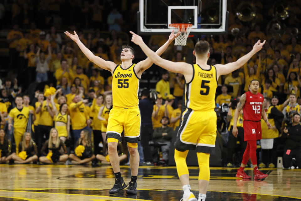 Iowa's Luka Garza (55) and CJ Fredrick (5) celebrate in front of Rutgers' Jacob Young (42) at the end of an NCAA college basketball game, Wednesday, Jan. 22, 2020, in Iowa City, Iowa. Iowa won 85-80. (AP Photo/Charlie Neibergall)