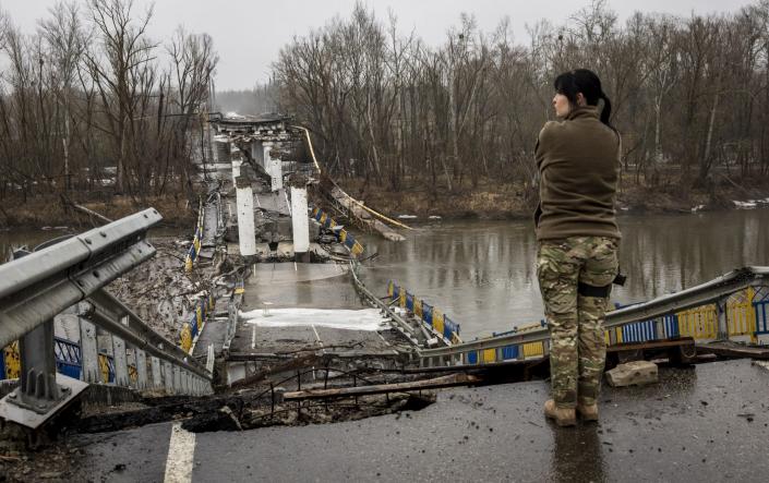 A Ukrainian Army soldier surveys a blown bridge in the Siverskiy-Donets river - John Moore/Getty Images Europe