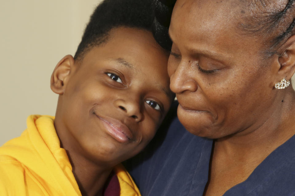 Tirzah Patterson and her son Jaques "Jake" Patterson pose for a picture at their home, Tuesday, May. 9, 2023, in Buffalo, N.Y. Jake, 13, is the youngest child of beloved church deacon Heyward Patterson, who was gunned down at a supermarket a year ago Sunday. Tirzah will dedicate this Mother’s Day to the hardest part of a mother’s job, trying to help her child make sense of tragedy.(AP Photo/Jeffrey T. Barnes)