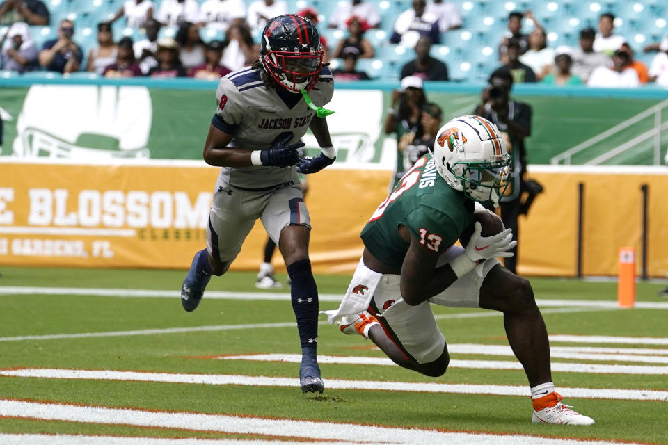 Florida A&M wide receiver Trevonte Davis (13) scores a touchdown in front of Jackson State cornerback Jalin Hughes, left, during the first half of the Orange Blossom Classic NCAA college football game, Sunday, Sept. 3, 2023, in Miami Gardens, Fla. (AP Photo/Lynne Sladky)