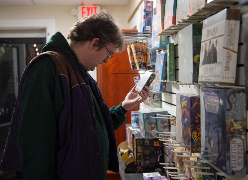 Stephen Johnson of Evansville looks for a card game that helps teach English at the Knight's Comics & Games in Henderson, Ky., Saturday evening, Nov. 20, 2021.