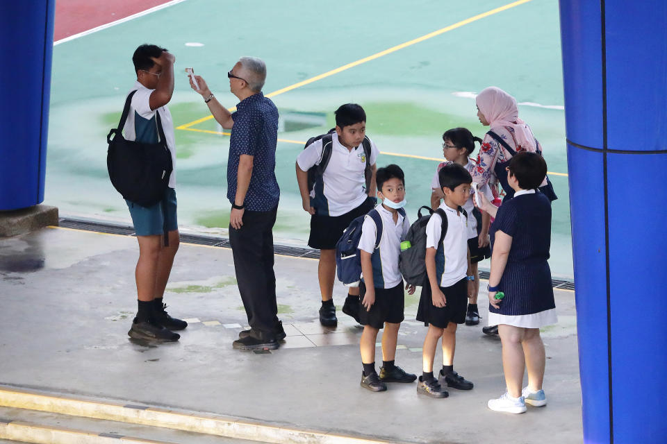 SINGAPORE - MARCH 24:  Students undergo temperature checks at the gate before entering school on March 24, 2020 in Singapore. The Ministry of Health has reported 54 new COVID-19 cases in new high, bringing the country's total to 509.  (Photo by Suhaimi Abdullah/Getty Images)