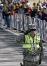 A military police officer salutes during opening ceremonies of the 118th Boston Marathon Monday, April 21, 2014 in Hopkinton, Mass. (AP Photo/Steven Senne)