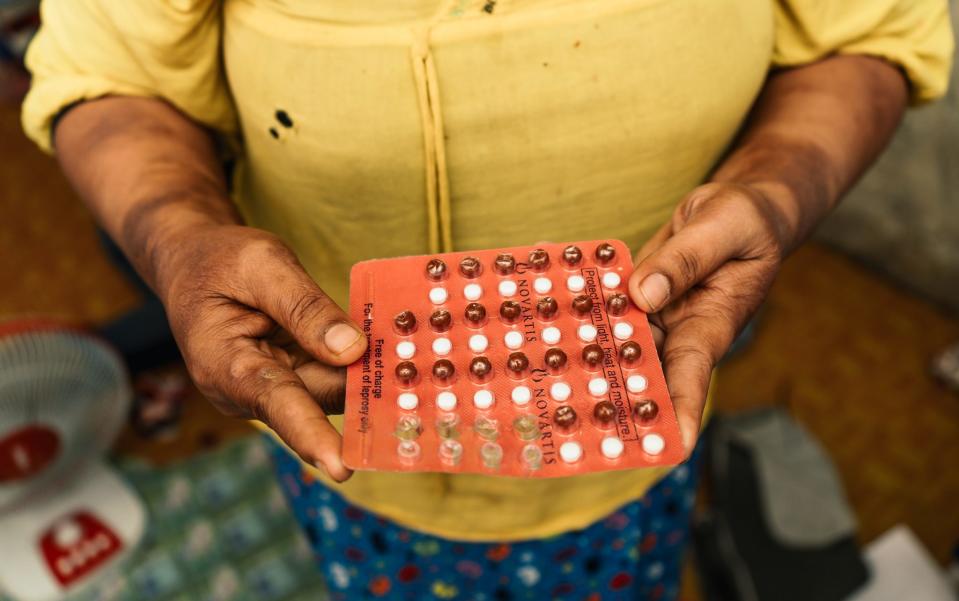 Sandar holding the medication she takes for her leprosy