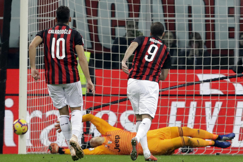 Juventus goalkeeper Wojciech Szczesny, center, saves as AC Milan's Gonzalo Higuain, right, shoots a penalty kick during a Serie A soccer match between AC Milan and Juventus, at Milan's San Siro stadium, Sunday, Nov. 11, 2018. (AP Photo/Luca Bruno)