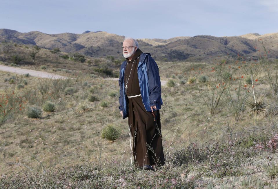 Boston Archdiocese Cardinal Sean O'Malley views the desert during a tour of areas used for human smuggling, early Tuesday, April 1, 2014, along the international border in Nogales, Ariz. O'Malley and a delegation of Roman Catholic leaders who serve along the U.S./Mexico were visiting the border town to bring awareness to immigration reform and to remember those who have died trying to cross the border in years past. (AP Photo/Matt York)