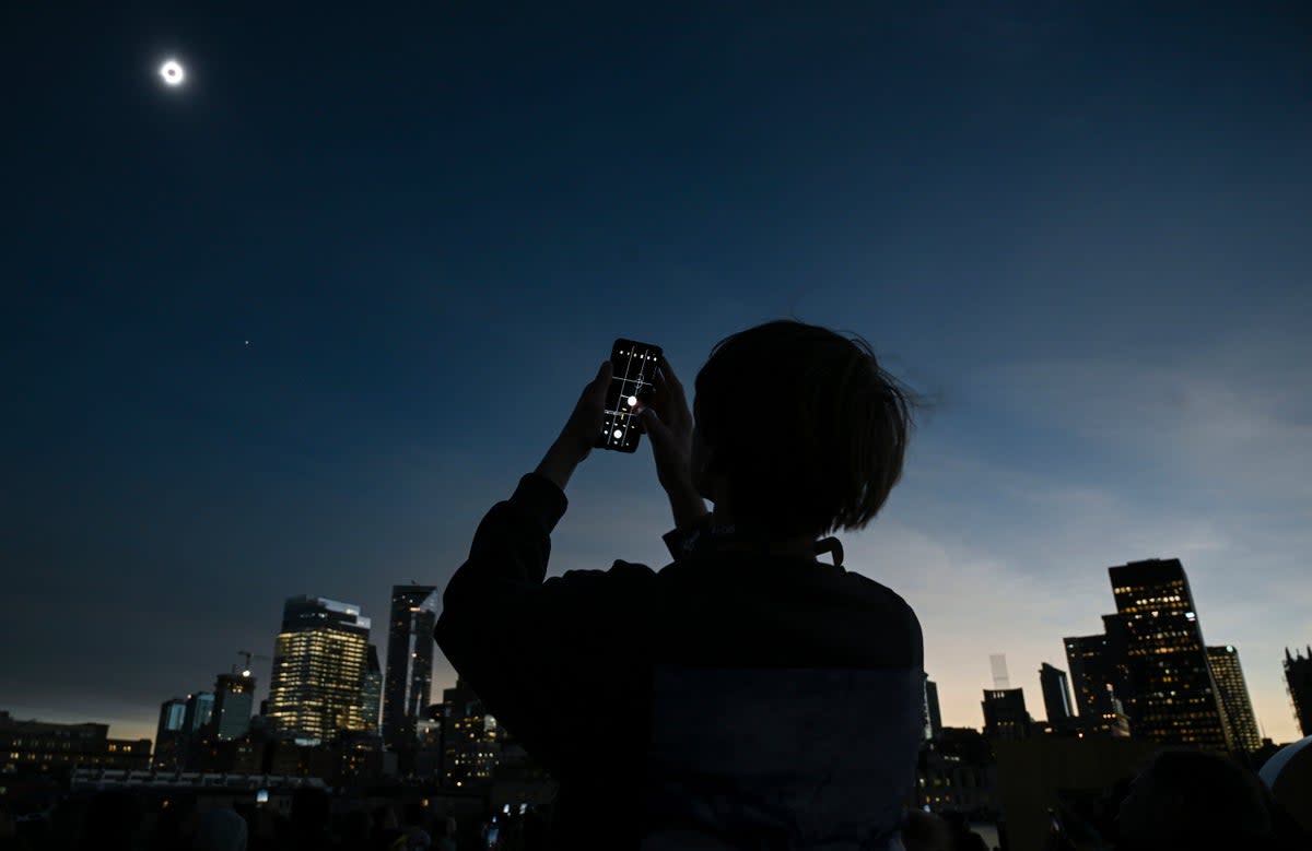 A young man views the solar eclipse in Montreal (AP)