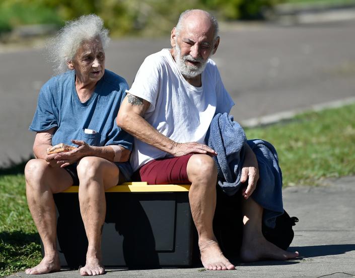 Joyce and Louis Concepcion sit on the side of Sumter Boulevard on Thursday afternoon after being rescued by first responders from their North Port home, which was flooded by about 3 feet of water during Hurricane Ian.