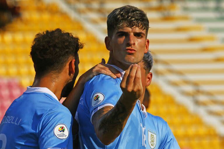 Santiago Homenchenko gesticula mientras recibe el saludo de dos compañeros tras marcar de cabeza el segundo gol de Uruguay, que venció por 3-0 a Perú y espera en el Preolímpico de Venezuela.