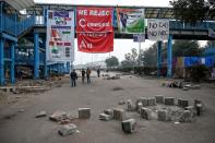 People stand under a bridge where banners rejecting India's new citizenship law are hung up at Shaheen Bagh area, that has been blocked off by demonstrators for almost 4 weeks, near the Jamia Millia Islamia university in New Delhi on January 6, 2020. - Dozens were hurt at a prestigious Indian university on January 5 in what police said were clashes between rival student groups but which an opposition politician blamed on a student organisation linked to Prime Minister Narendra Modi. (Photo by Money SHARMA / AFP) (Photo by MONEY SHARMA/AFP via Getty Images)