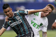 LA Galaxy midfielder Efrain Alvarez, left, hits Austin FC defender Zan Kolmanic in the face as they battle for the ball during the first half of a Major League Soccer match Saturday, May 15, 2021, in Carson, Calif. (AP Photo/Mark J. Terrill)