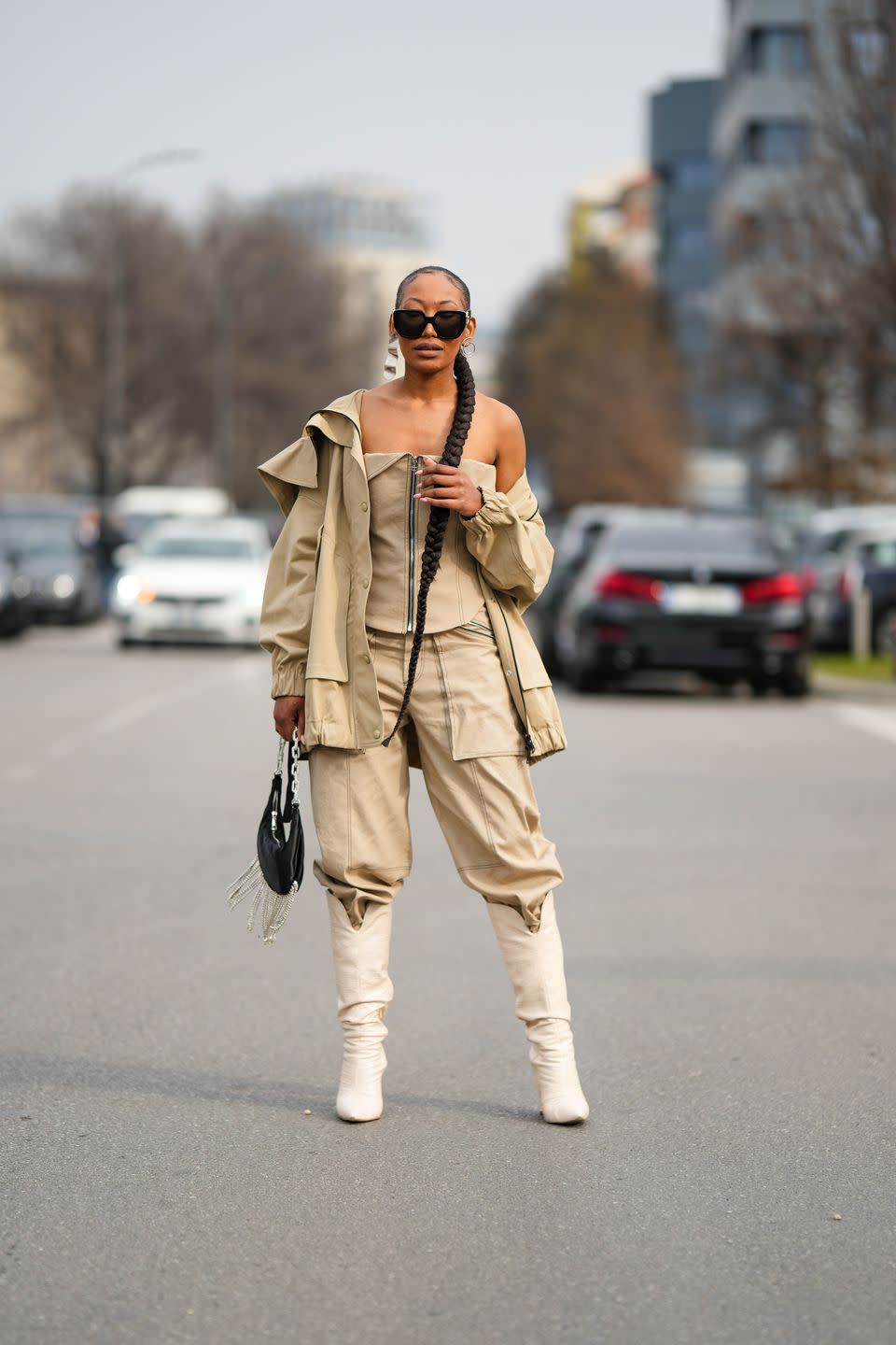 milan, italy february 23 a guest wears black sunglasses from gucci, a beige zipper chest shoulder off cargo top, a matching beige cargo jacket, beige cargo large pants, a black shiny leather fringed handbag, white shiny leather pointed heels knees boots high boots, outside prada, during the milan fashion week womenswear fallwinter 20232024 on february 23, 2023 in milan, italy photo by edward berthelotgetty images