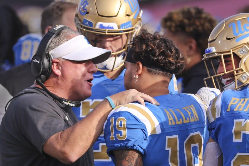 Los Angeles, CA - November 20: UCLA head coach Chip Kelly, left, congratulates UCLA running back Kazmeir Allen after his first quarter touchdown against USC at Los Angeles Memorial Coliseum in Los Angeles on Saturday, Nov. 20, 2021. (Allen J. Schaben / Los Angeles Times)