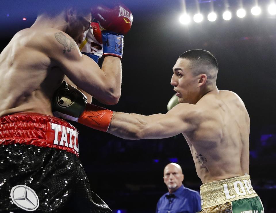FILE - In this Saturday, April 20, 2019, file photo, Teofimo Lopez, right, punches Finland's Edis Tatli during the first round of a NABF lightweight championship boxing match in New York. In ordinary times Vasiliy Lomachenko and Teofimo Lopez would be the fight of the fall, a lightweight title match about as compelling as it gets in the boxing world these days. Instead of a big crowd, the only fans at the MGM Grand conference center will be a few hundred sponsors and first responders with special invites. And, instead of pay-per-view, the fight will be televised live on ESPN, guaranteeing a larger audience than a pay-per-view even if the money isn’t nearly the same. (AP Photo/Frank Franklin II, File)