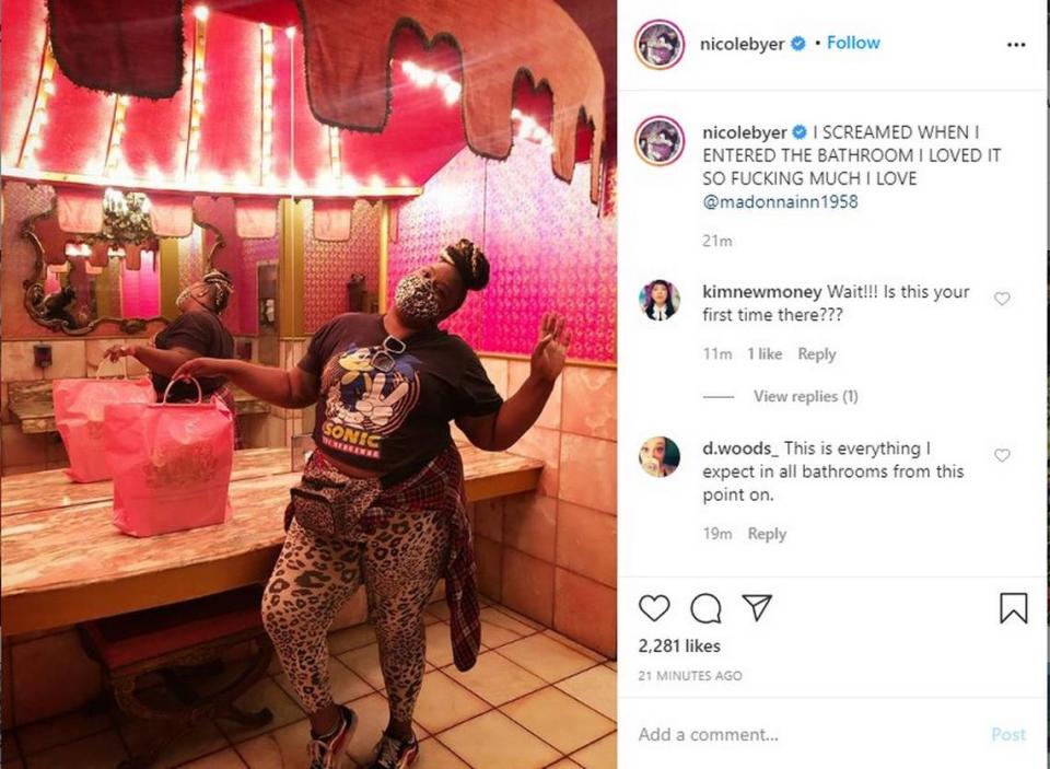 A mask-wearing Nicole Byer poses for a picture at the women’s restroom at the Madonna Inn in San Luis Obispo.