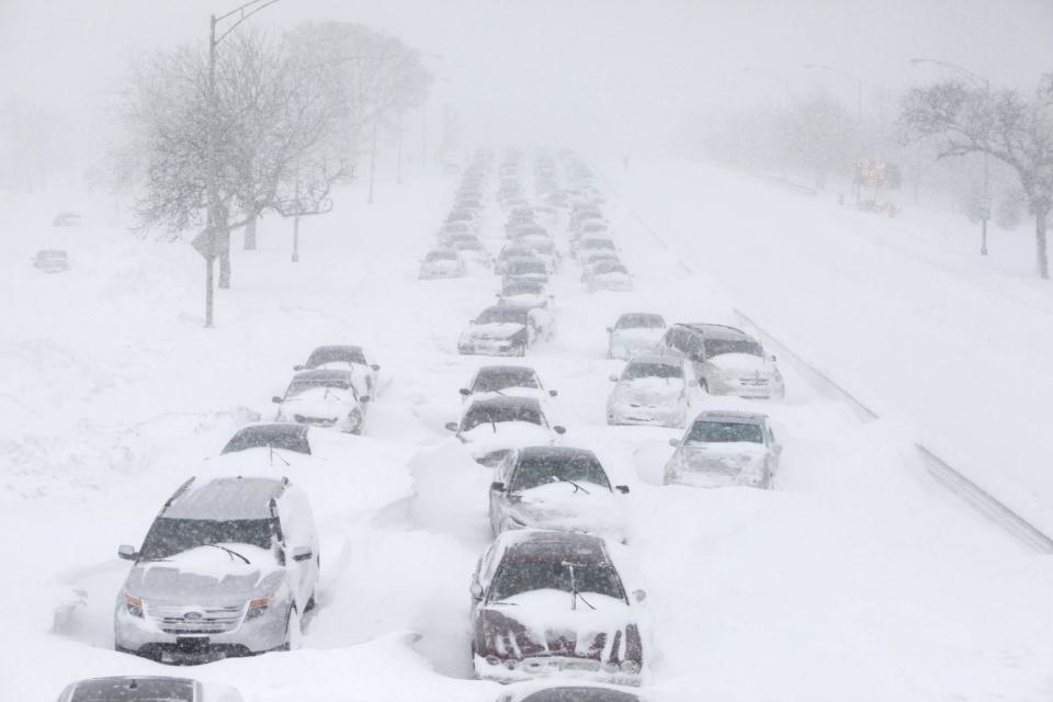 FILE - In this Feb. 2, 2011 file photo, hundreds of cars are seen stranded on Lake Shore Drive in Chicago. Global warming is rapidly turning America the beautiful into America the stormy, sneezy and dangerous, according to a new U.S. federal scientific report released Tuesday, May 6, 2014. (AP Photo/Kiichiro Sato)