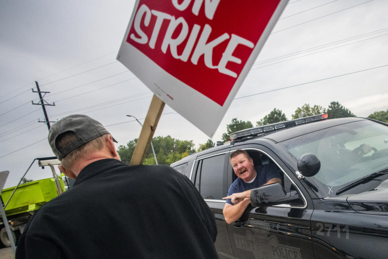 Flint Police ask protestors to let traffic through in larger waves as General Motors employees stand with United Auto Workers members and labor supporters outside of the Flint Metal Center as part of the national UAW strike against GM on Monday, Sept. 16, 2019 in Flint, Mich. Thousands of members of the United Auto Workers walked off General Motors factory floors or set up picket lines early Monday as contract talks with the company deteriorated into a strike. (Jake May/The Flint Journal via AP)