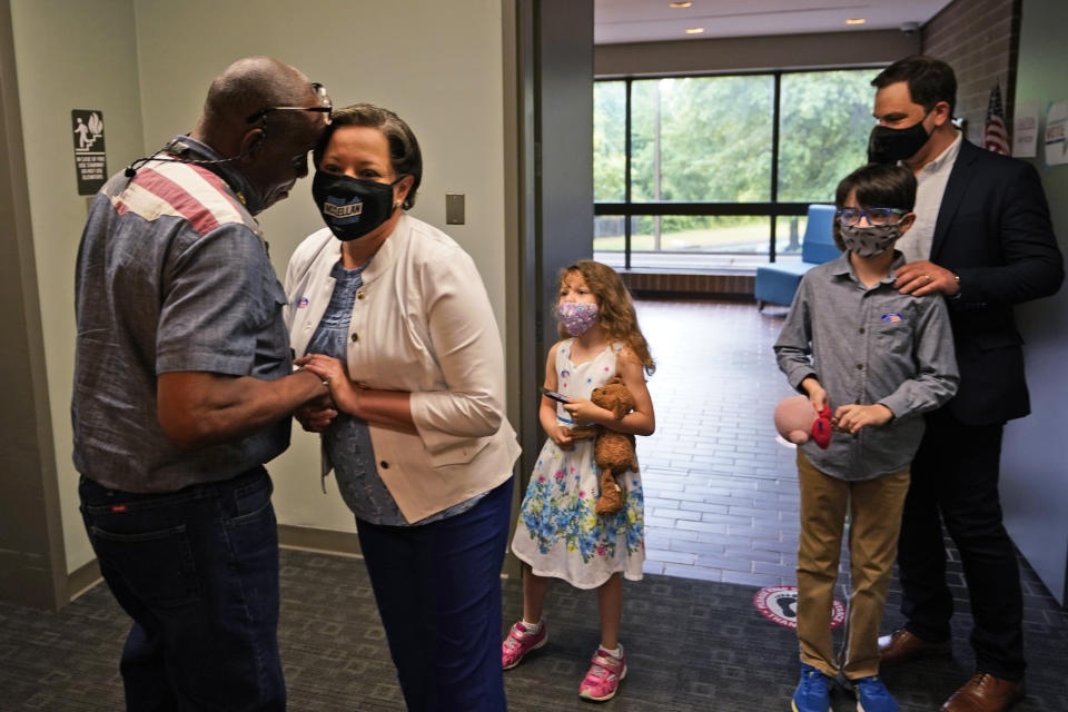 Democratic gubernatorial candidate, Virginia State Sen. Jennifer McClellan, second from left, greets a voter at an early voting location as her family looks on in Richmond, Va., Saturday, May 29, 2021. McClellan faces four other Democrats in the primary. (AP Photo/Steve Helber)