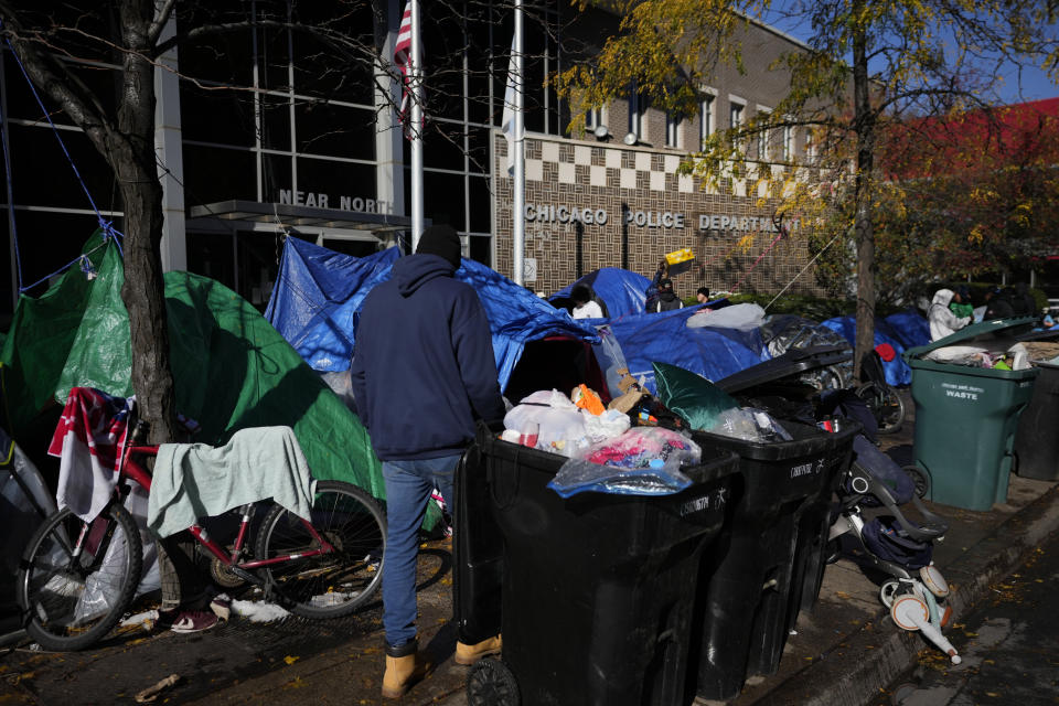 FILE - A man walks through a small tent community for migrants, Wednesday, Nov. 1, 2023, near a Northside police station in Chicago. Nervous officials in suburbs and outlying cities near Chicago and New York are giving migrants arriving from the southern border a cold shoulder. When a plane with 355 migrants arrived in Rockford, Illinois, from San Antonio early New Year's Day, officials there said the migrants wouldn't be staying. The moves come amid attempts to circumvent new limits on dropping migrants in the two cities, opening a new front in response to efforts led by Texas Gov. Greg Abbott to pay for migrants to leave his state. (AP Photo/Charles Rex Arbogast, File)