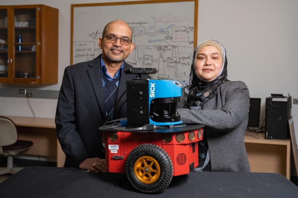 Sajay Arthanat, professor of occupational therapy (left) and Momotaz Begum, assistant professor of computer science (right) co-principal investigators with prototype of robot for aging patients with Alzheimer’s Disease and related dementia.